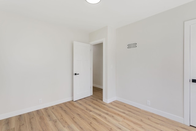 spare room with baseboards, visible vents, and light wood-type flooring