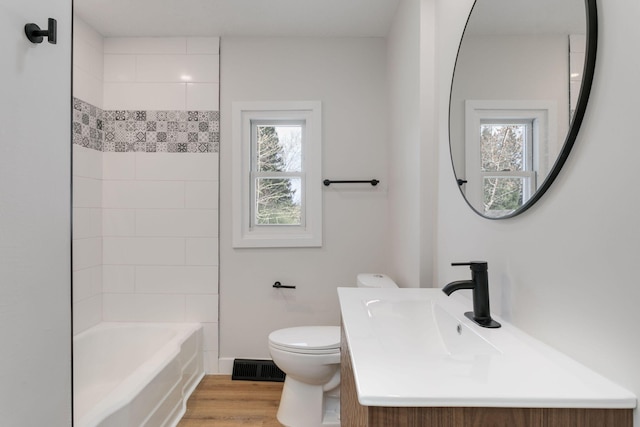 full bath featuring shower / bathing tub combination, visible vents, wood finished floors, vanity, and toilet