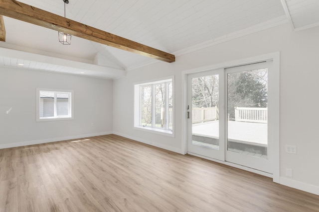 empty room featuring baseboards, vaulted ceiling with beams, light wood-type flooring, and a wealth of natural light