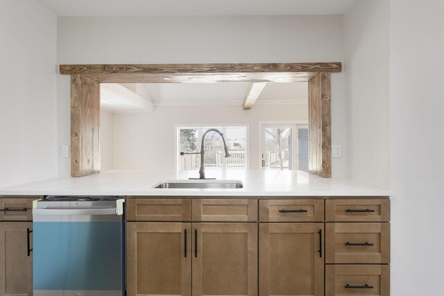 kitchen with a sink, a peninsula, dishwasher, and light countertops