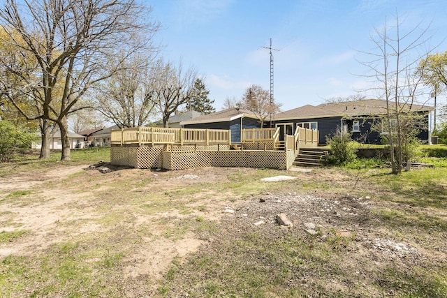rear view of property featuring a deck and a shingled roof