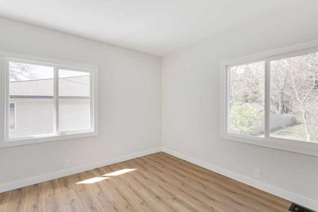 unfurnished room featuring baseboards, a healthy amount of sunlight, and light wood-style flooring