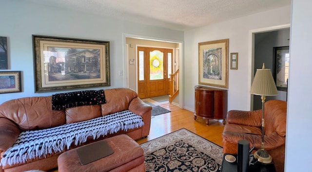 living area with light wood finished floors and a textured ceiling
