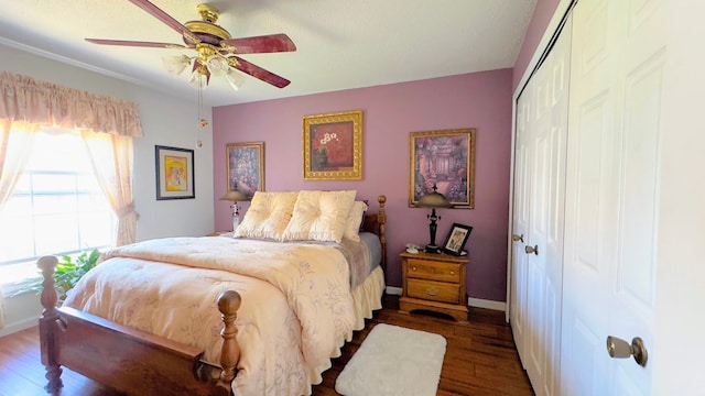 bedroom featuring a closet, baseboards, ceiling fan, and wood finished floors