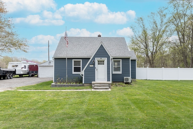 view of front of home featuring fence, an outbuilding, roof with shingles, and a front yard