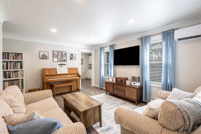 living room with an AC wall unit, recessed lighting, wood finished floors, and a wealth of natural light