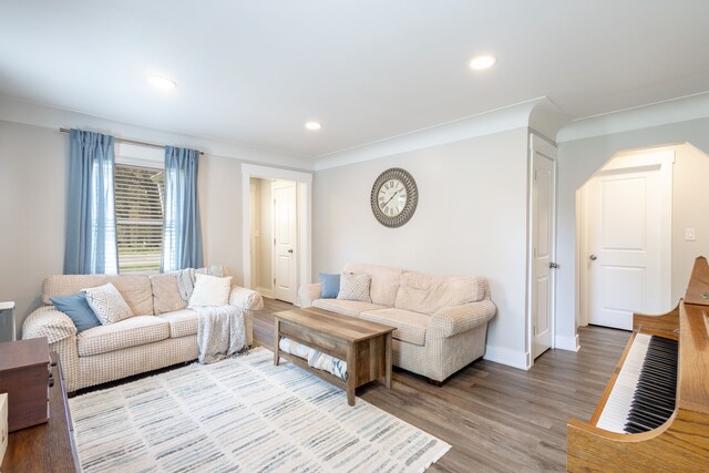 living area with recessed lighting, arched walkways, baseboards, and light wood-type flooring