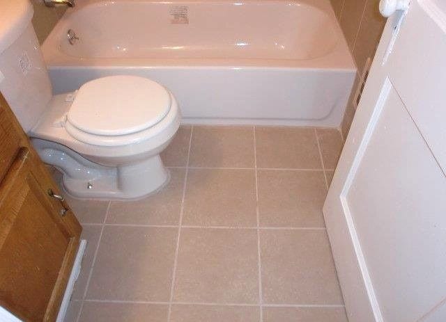 19724 Elkhart St, Harper Woods, MI 48225 - bathroom with toilet, tile patterned floors, and a tub to relax in