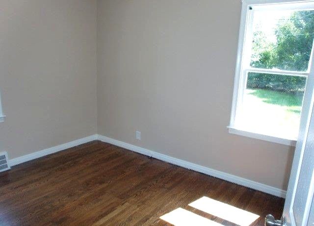 19724 Elkhart St, Harper Woods, MI 48225 - empty room with baseboards, dark wood-style floors, and a wealth of natural light