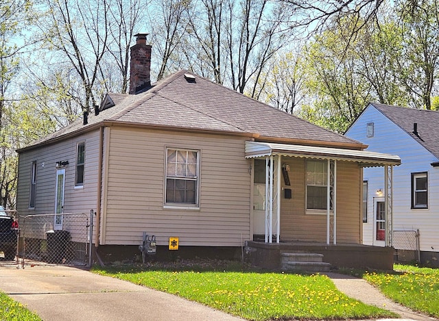 19724 Elkhart St, Harper Woods, MI 48225 - bungalow-style house featuring a porch, a chimney, and a front lawn