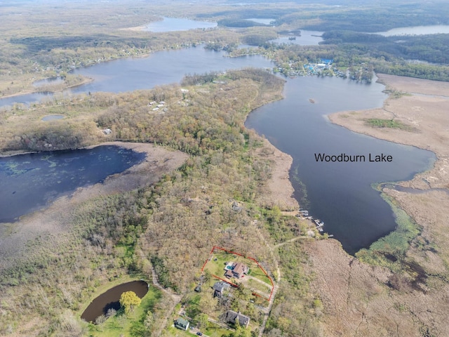 drone / aerial view featuring a water view and a wooded view