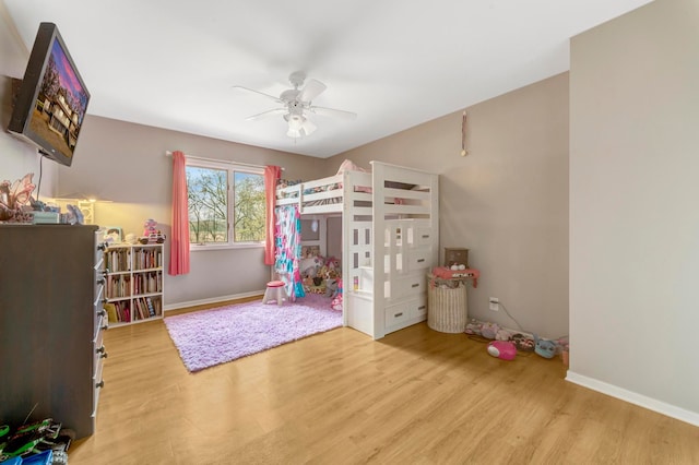 bedroom with a ceiling fan, baseboards, and wood finished floors