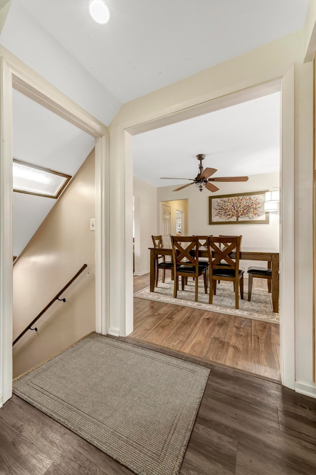 hallway with an upstairs landing and wood finished floors