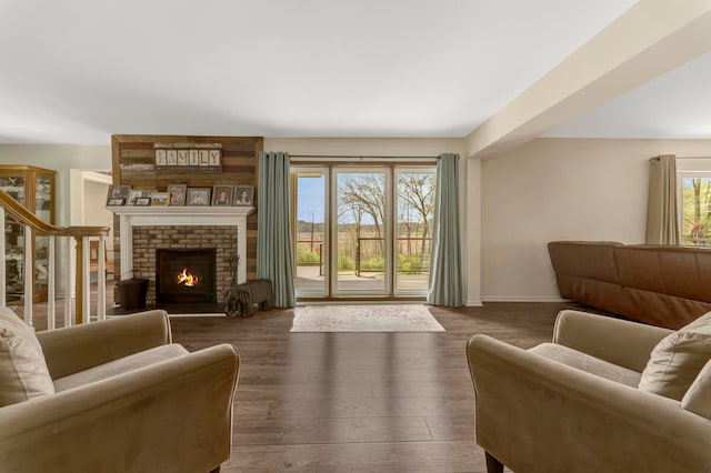 living area featuring baseboards, wood finished floors, and a fireplace