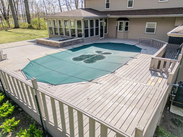 view of swimming pool featuring a wooden deck, a sunroom, a patio area, a lawn, and central air condition unit