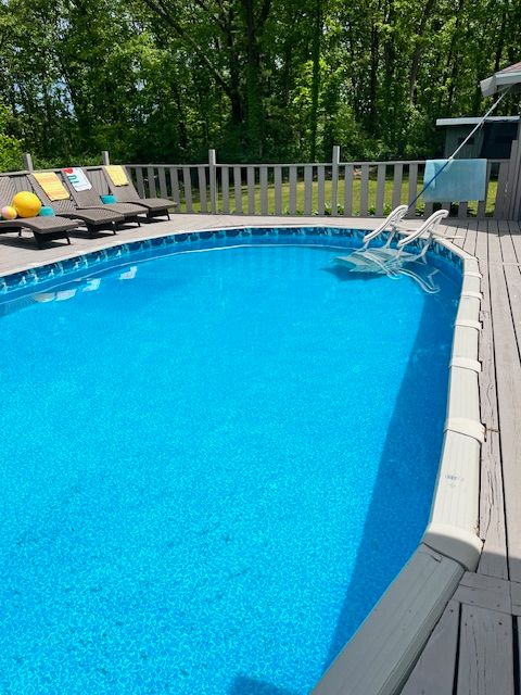 view of swimming pool with a fenced in pool and a wooden deck