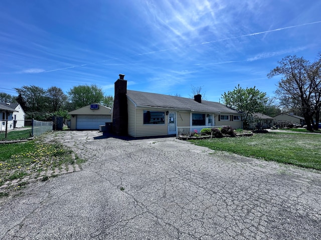ranch-style house with a detached garage, fence, a chimney, and an outdoor structure
