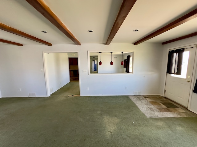 unfurnished living room with carpet floors, baseboards, beam ceiling, and visible vents