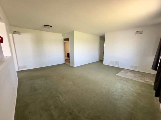 empty room featuring visible vents and carpet flooring