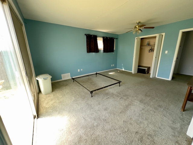 unfurnished bedroom with carpet floors, visible vents, a closet, baseboards, and a ceiling fan