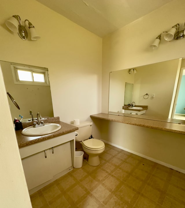 half bathroom featuring vanity, tile patterned floors, and toilet