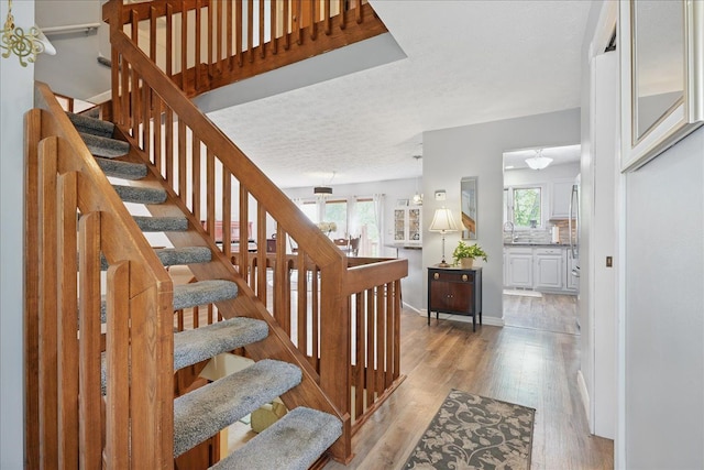 stairs with baseboards and wood finished floors
