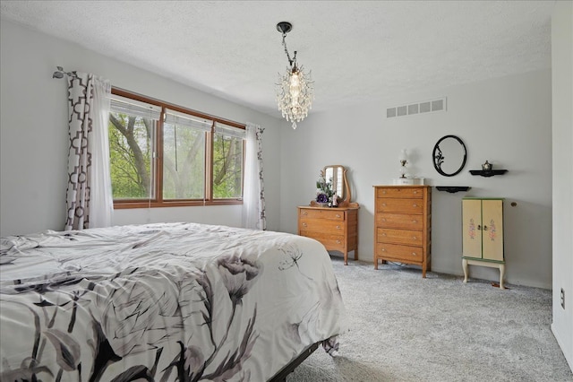 carpeted bedroom featuring a textured ceiling, visible vents, and a notable chandelier