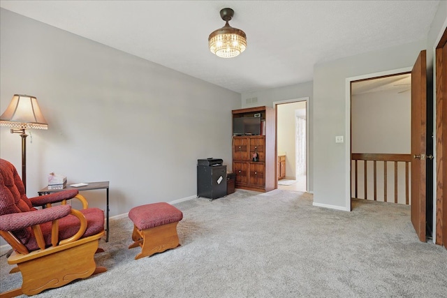 sitting room with baseboards, visible vents, and carpet
