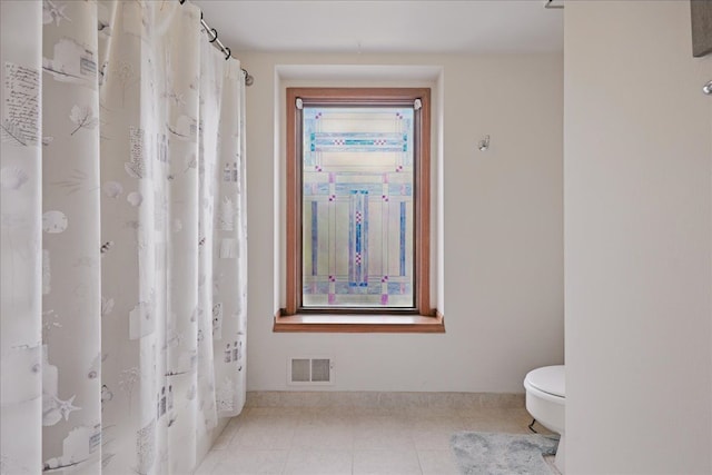 bathroom featuring tile patterned floors, toilet, visible vents, and a shower with shower curtain