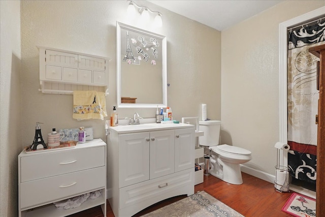 bathroom with vanity, toilet, and wood finished floors