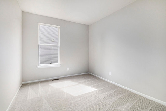 empty room with visible vents, carpet, and baseboards