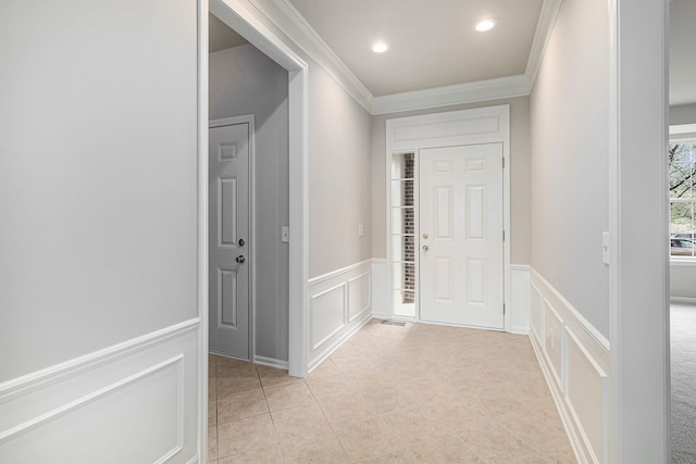 entryway featuring a wainscoted wall, ornamental molding, a decorative wall, recessed lighting, and light tile patterned flooring