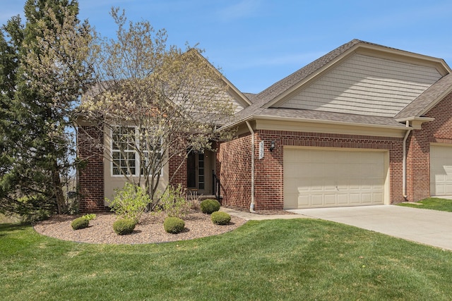 view of front of home featuring brick siding, driveway, a front yard, and a garage