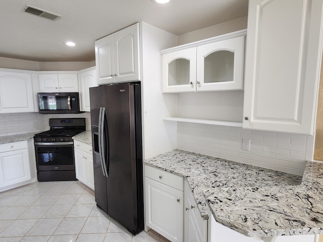 kitchen featuring decorative backsplash, visible vents, light stone counters, black appliances, and white cabinetry