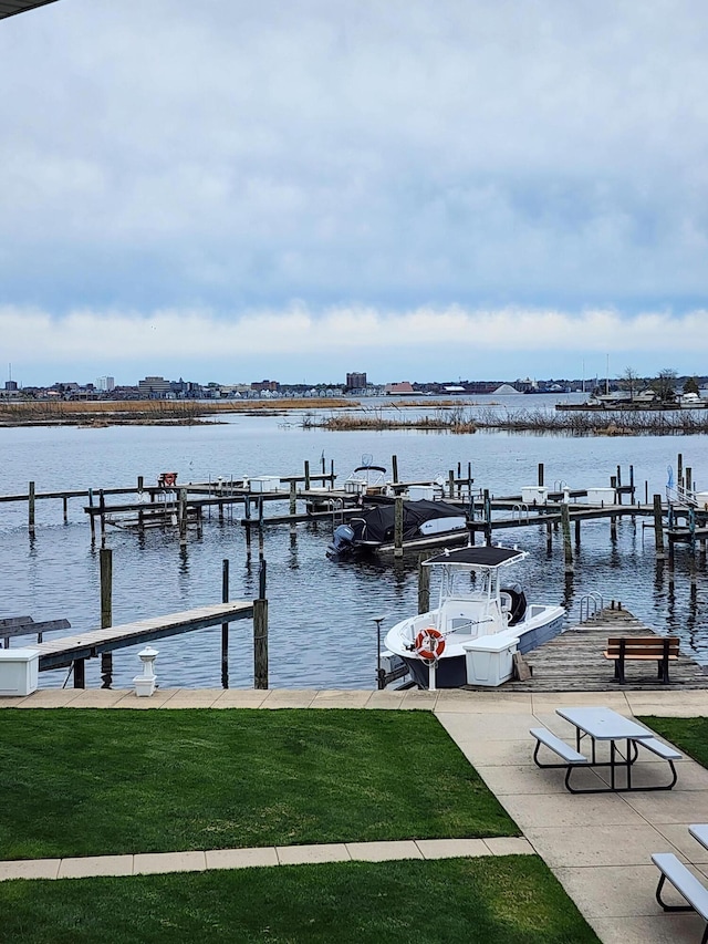 dock area featuring a lawn and a water view