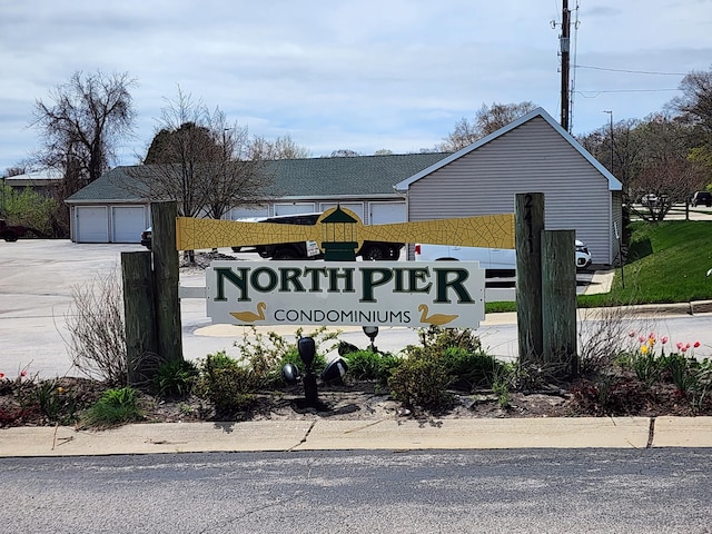 community sign featuring a detached garage