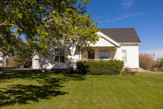 exterior space featuring a front lawn, roof with shingles, and covered porch