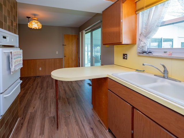 kitchen with light countertops, a healthy amount of sunlight, a warming drawer, and a wainscoted wall