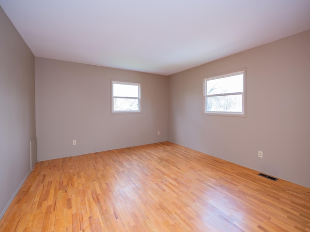 empty room featuring visible vents and light wood finished floors