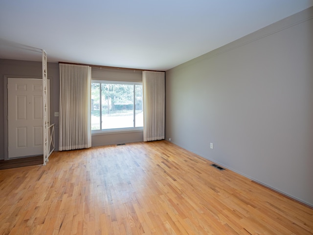 empty room featuring visible vents and wood finished floors