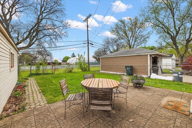 view of patio with outdoor dining area, an outbuilding, a fire pit, and a fenced backyard