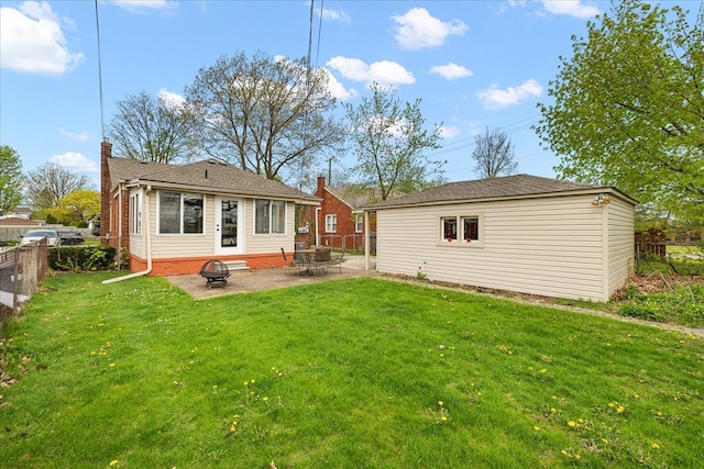 back of property with a chimney, fence private yard, an outdoor structure, a yard, and a patio