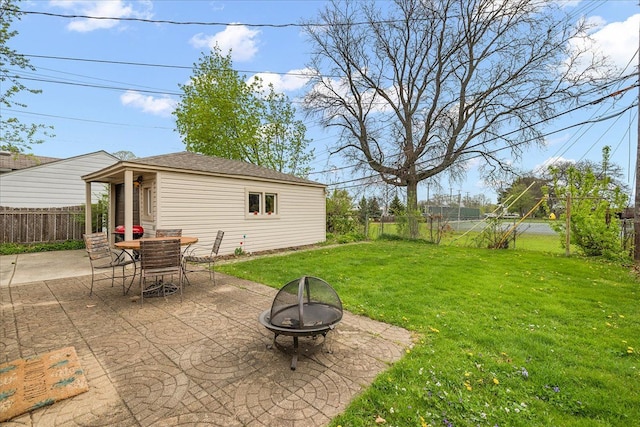 view of patio with an outbuilding, a fenced backyard, and an outdoor fire pit