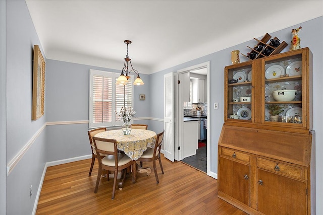 dining area with baseboards and wood finished floors