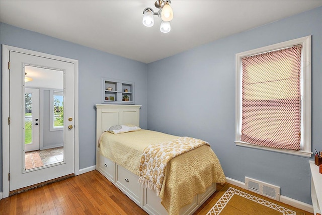 bedroom featuring visible vents, baseboards, and hardwood / wood-style flooring