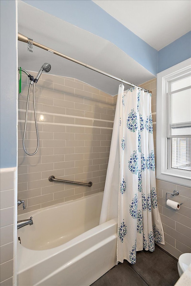 bathroom with tile walls and shower / tub combo