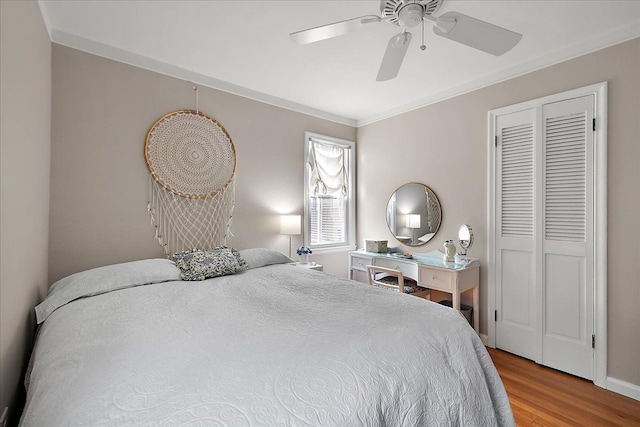 bedroom with a ceiling fan, wood finished floors, and ornamental molding
