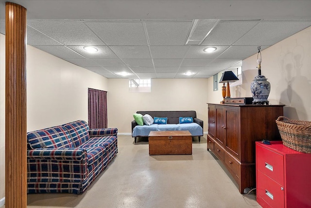 living room with recessed lighting, baseboards, a paneled ceiling, and finished concrete floors
