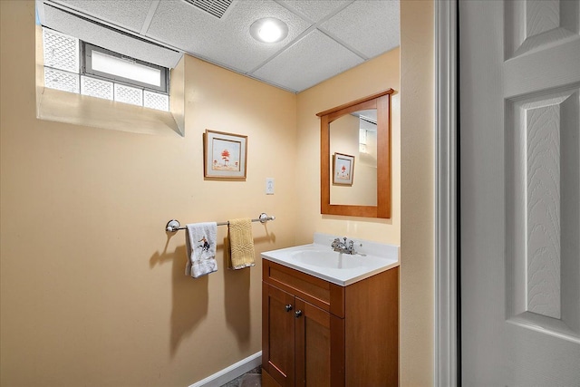 bathroom featuring visible vents, a drop ceiling, and vanity