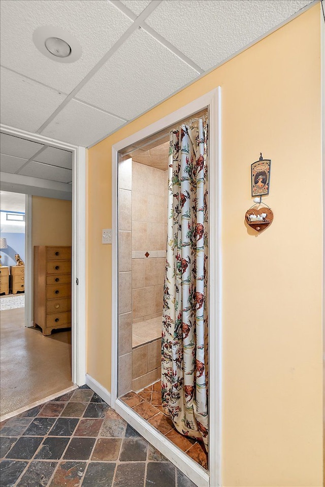 bathroom featuring stone finish flooring and a shower stall